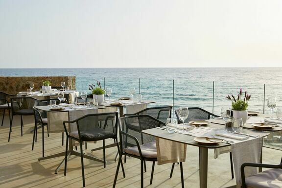 Tables are set along the beach at Tortuga Corfu Pelekas Restaurant & Bar